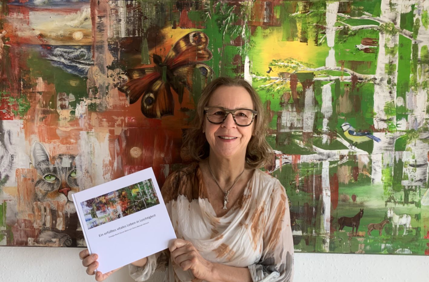 Die Autorin Petra Wenski-Hänisch mit ihrem Energie-Kunst-Buch-Werk Ein erfülltes vitales Leben in Leichtigkeit vor ihrem Gemälde natürlich natürlich